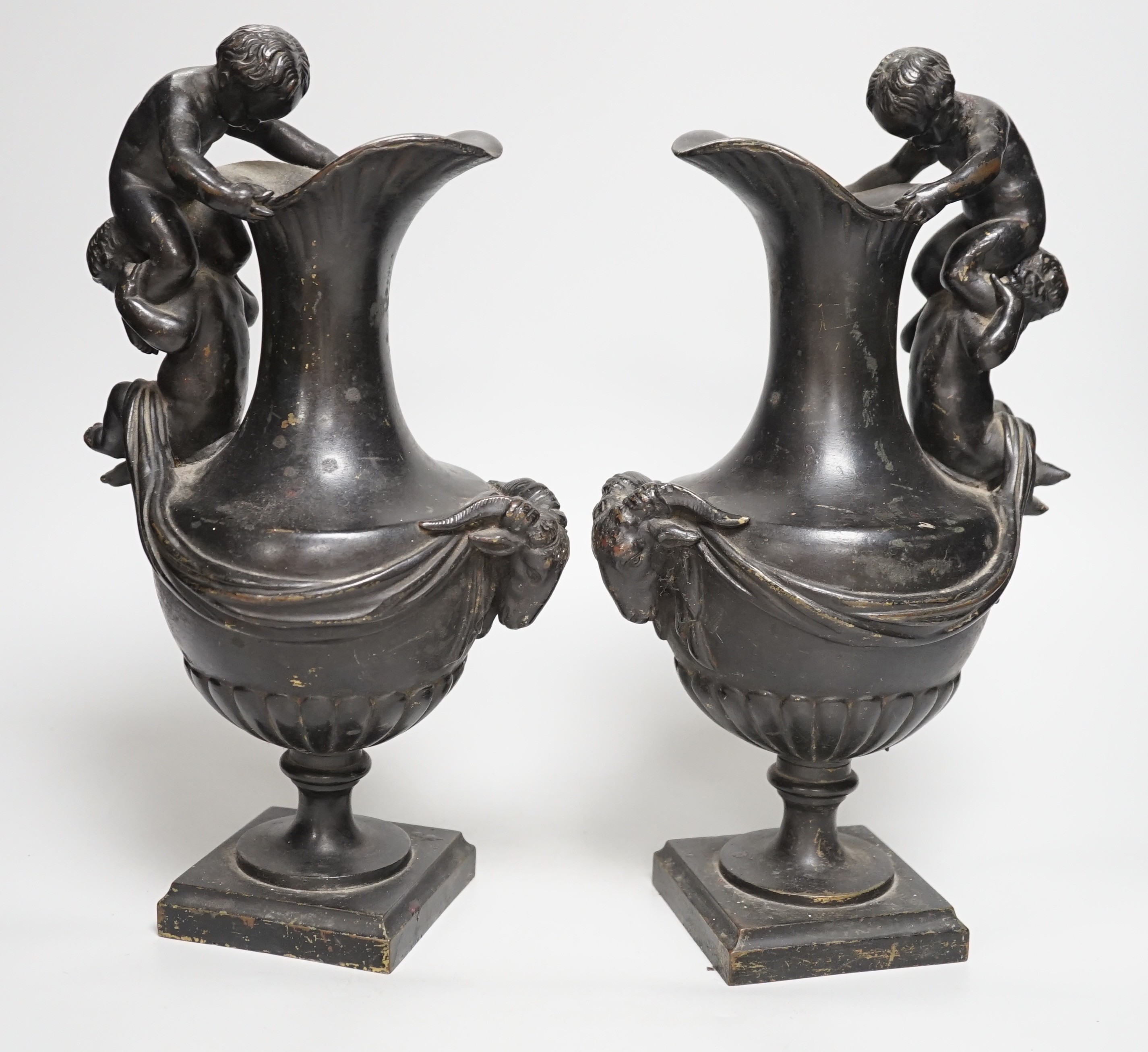 A pair of classical revival bronze urn side ornaments with cast rams head bodies. 32cm tall